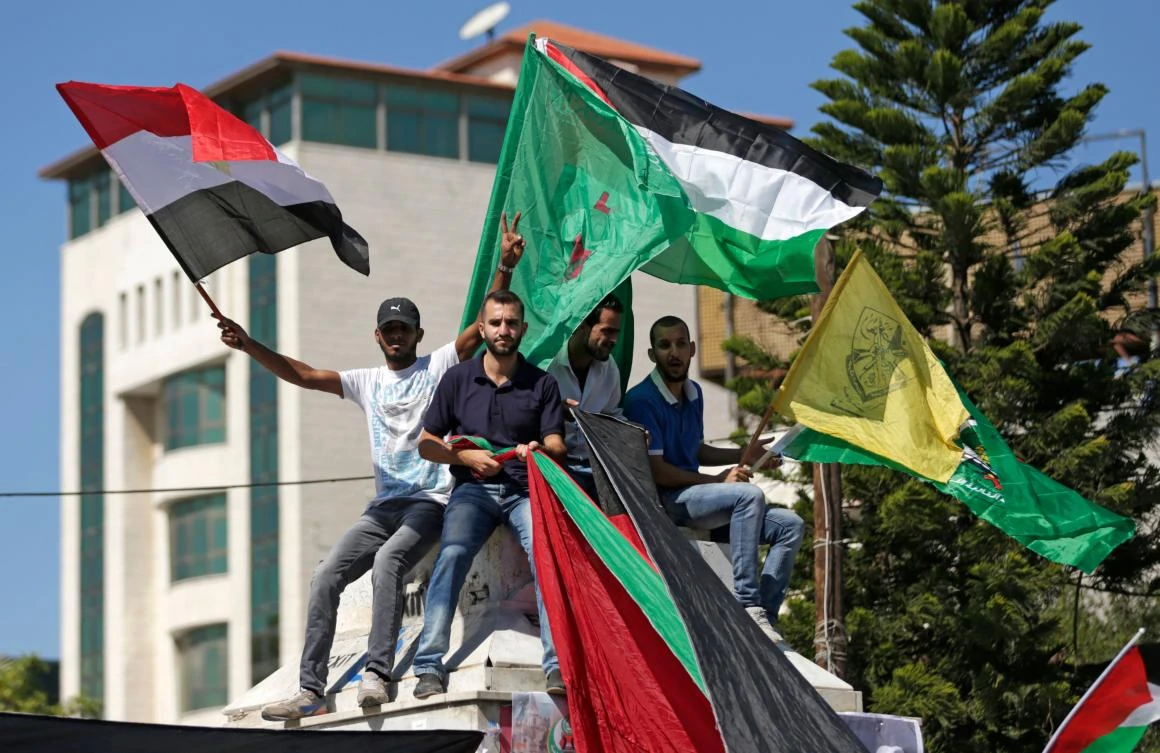This file photo taken on Oct. 12, 2017 shows Palestinians waving the flags of the Fatah party, Egypt and Palestine as they gather in Gaza City to celebrate after rival Palestinian factions Hamas and Fatah reached an agreement on ending a decade-long split following talks mediated by Egypt. Hamas is due to end its decade-long dominance of the Gaza Strip by Dec. 1, 2017 in its biggest step yet toward Palestinian unity, but hopes raised by a reconciliation deal have already given way to doubts. (AFP/Mahmud Hams)