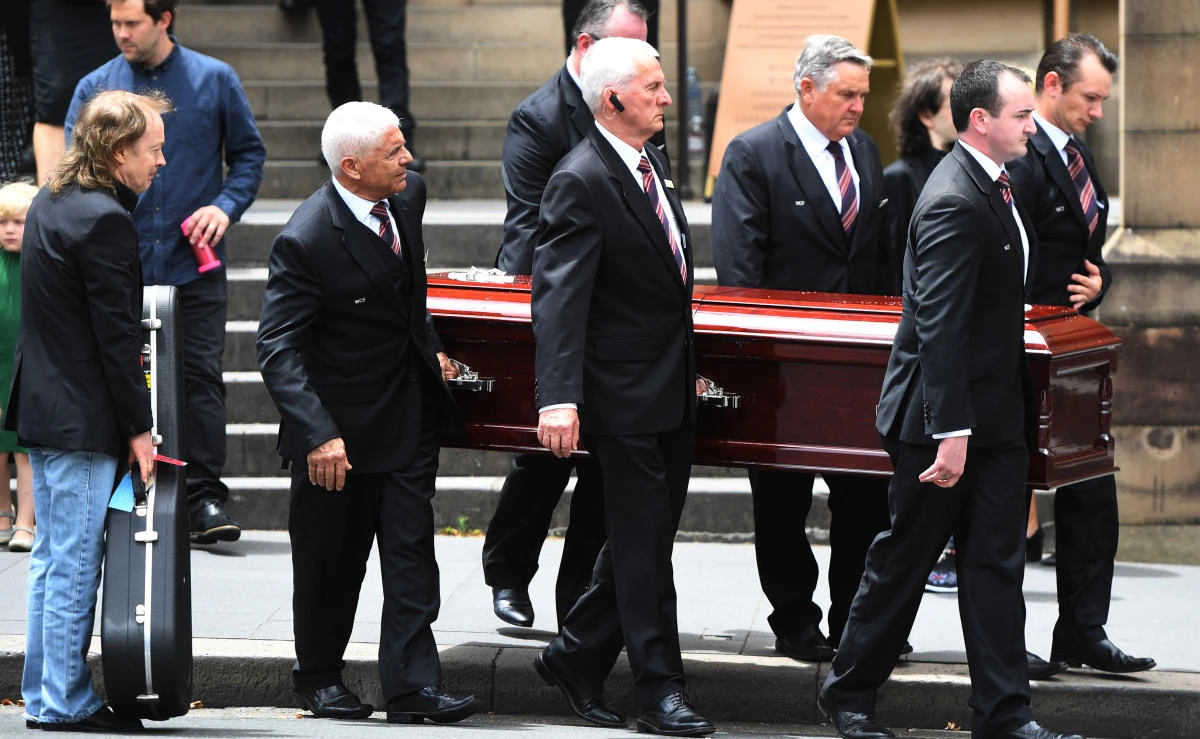 Angus Young holds a guitar as the casket of his brother AC/DC co-founder and guitarist Malcolm Young is carried to a hearse following his funeral at St. Mary’s Cathedral in Sydney on November 28, 2017. (AAP/Dean Lewins/via REUTERS)