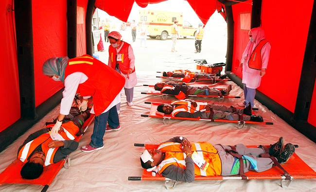 Rescue workers help participants simulating injured people during "Emergency Evacuation Operations" exercises at King Khalid International Airport in Riyadh April 29, 2013. The exercises, demonstrating preventive evacuations and rescue efforts in the event of an aircraft-related incident, showed the cooperation between the Civil Aviation Authority, Civil Defense, Red Crescent and Saudi Police and Security. REUTERS/Faisal Al Nasser (SAUDI ARABIA - Tags: SOCIETY TRANSPORT)