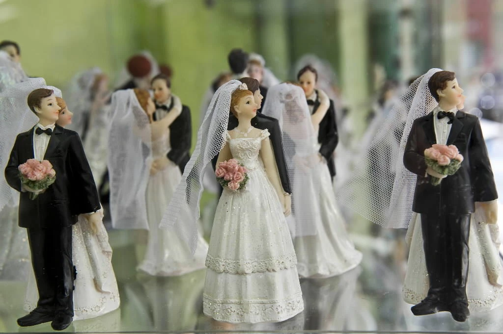 Miniatures of brides and grooms are displayed in a window display of a bridal store. (AFP)