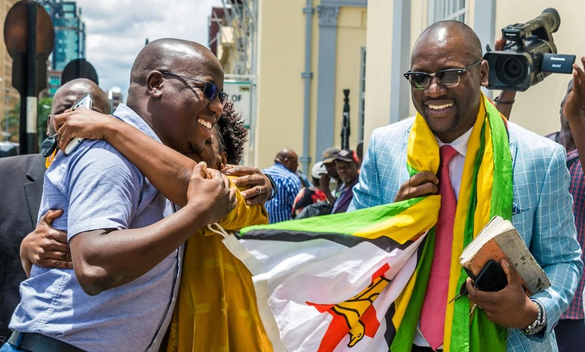 Zimbabwe Pastor Evan Mawarire (R) celebrates with his supporters on November 29, 2017 outside the High Court in Harare where he was acquitted of all charges against him including trying to over throw Zimbabwean government. (AFP / Jekesai Njikizana)