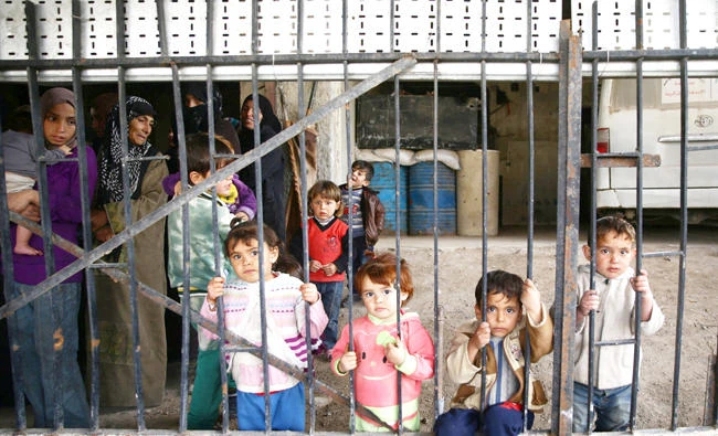Syrian children seen through iron grill in the town of Nashabiyeh, Eastern Ghouta. (Reuters)