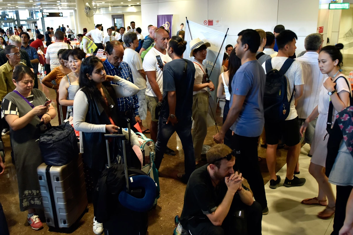Passengers gather at the Gusti Ngurah Rai International airport in Denpasar, Bali on November 27. A change in wind direction blew towering columns of ash and smoke away from the airport prompted authorities to re-open the island’s main international gateway on Wednesday afternoon. (AFP)