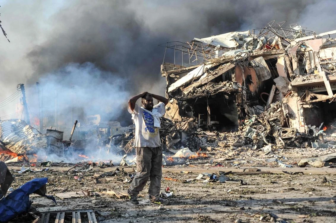 A Somali man reacts next to a body on the site where a car bomb exploded at the center of Mogadishu on October 14, 2017. (AFP file photo)