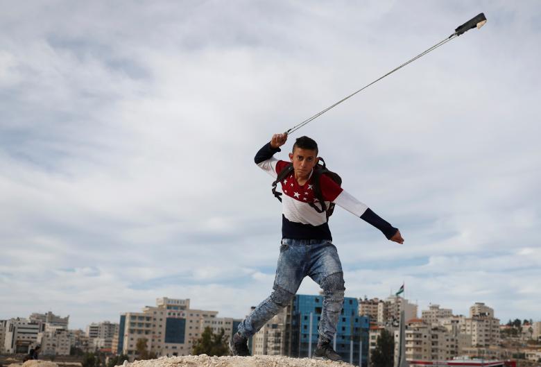 December 12, 2017 — A Palestinian protester slings a rock at Israeli forces during a protest against U.S. President Donald Trump's decision to recognize Jerusalem as the capital of Israel, near the Jewish settlement of Beit El, near the West Bank city of Ramallah. (REUTERS)