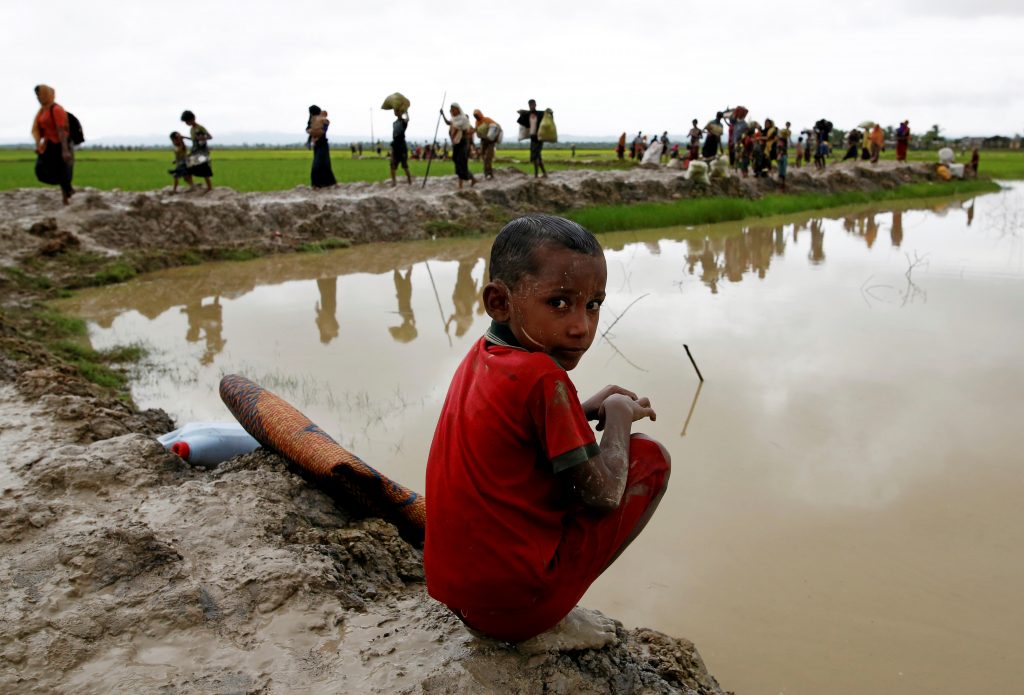 September 1, 2017 — A Rohingya refugee boy reacts to the camera as he sits in the mud after traveling over the Bangladesh-Myanmar border in Teknaf, Bangladesh. (REUTERS)