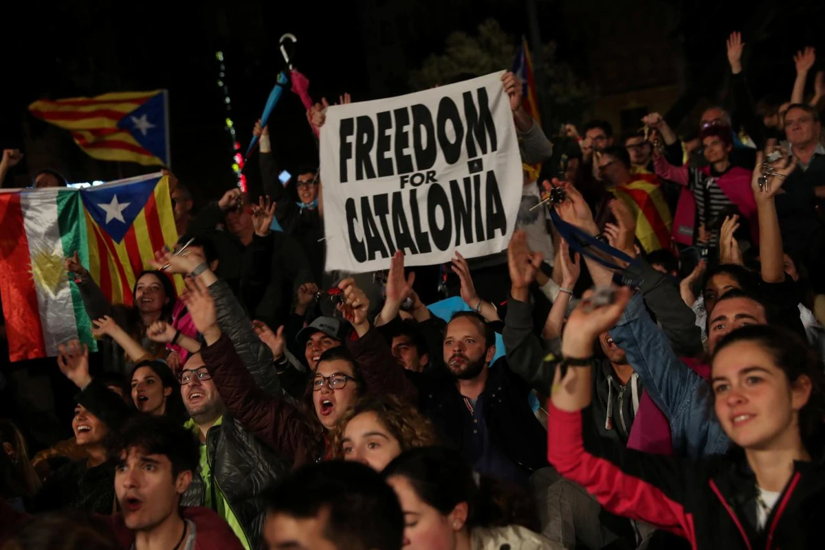October 1, 2017 — People react as they gather at Plaza Catalunya after voting ended for the banned independence referendum, in Barcelona, Spain. (REUTERS)