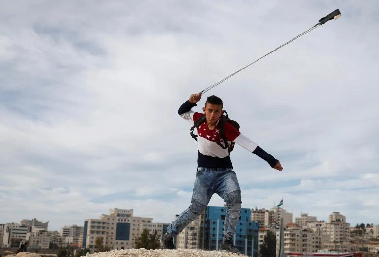 December 12, 2017 — A Palestinian protester slings a rock at Israeli forces during a protest against U.S. President Donald Trump's decision to recognize Jerusalem as the capital of Israel, near the Jewish settlement of Beit El, near the West Bank city of Ramallah. (REUTERS)