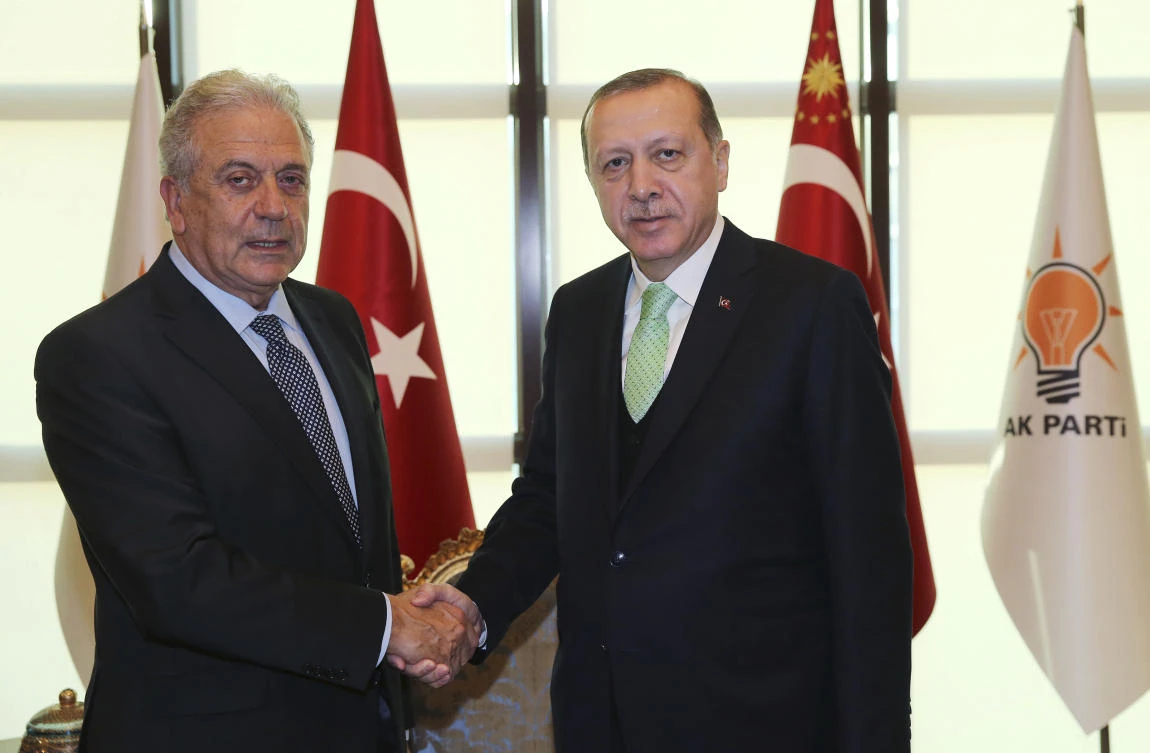 Turkey's President Recep Tayyip Erdogan, right, shakes hands with Dimitris Avramopoulos, EU Commissioner for Migration, Home Affairs and Citizenship, in Ankara, Turkey, on Nov. 27, 2017. (Pool via AP)