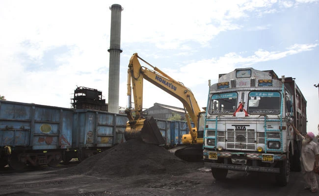 In this July 14, 2017 photo, domestically produced petroleum coke is loaded onto a truck to be transported to factories, at a railway station in Rampur, India. Petcoke is the black, bottom-of-the-barrel oil-refining waste that containing more sulfur than what's allowed in coal. India's petcoke appetite grew so voracious that it began producing and selling its own, and Indian refineries today are making about as much as the country is importing. (AP Photo/Vaishnavee Sharma)