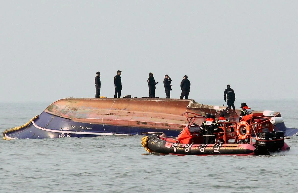 Above, South Korean coast guard members search for missing persons after a fishing boat crashed with a fuel tanker at sea near the western port city of Incheon on December 3. (Yonhap via AFP)