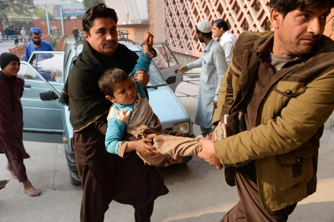 Afghan volunteers carry an injured boy to a hospital after a suicide attack in Jalalabad on December 3. (AFP)