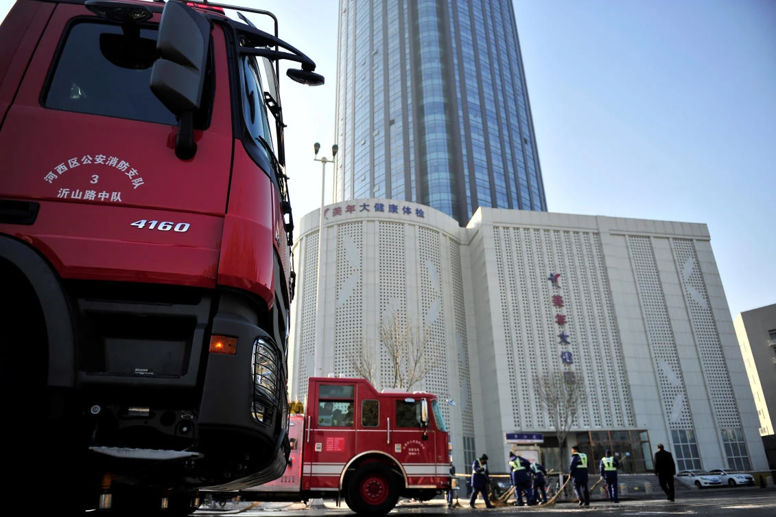 Above, fire trucks are seen outside a skyscraper after a fire broke out around 4am on the 38th floor of a serviced apartment in Tianjin on December 1. (Reuters)