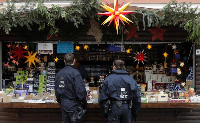 German police officers talk with a vendor on a Christmas market a day after a suspicious object was found in Potsdam, eastern Germany on Dec. 2, 2017. (AP Photo/Markus Schreiber)