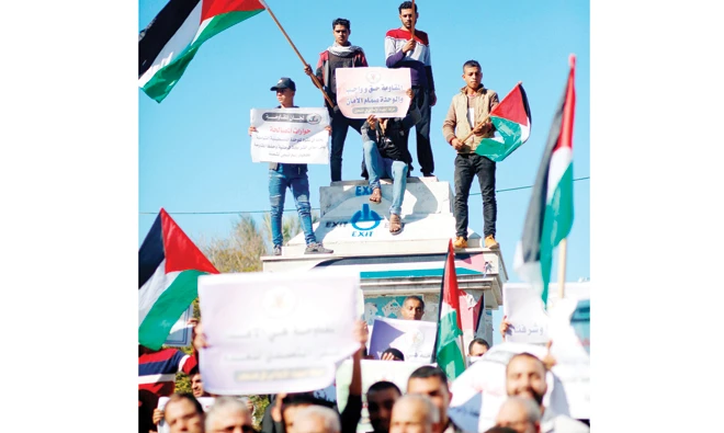 Palestinians wave the national flag during a demonstration on Sunday in Gaza City in support of the reconciliation talks between Hamas and Fatah. (AFP)
