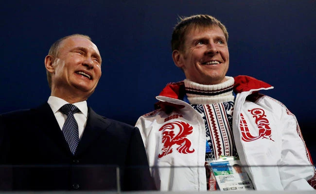 Russian President Vladimir Putin (L) laughs with Russia's gold medallist bobsleigh athlete Alexander Zubkov during the closing ceremony for the 2014 Sochi Winter Olympics on February 23, 2014. (REUTERS/Phil Noble/File Photo)