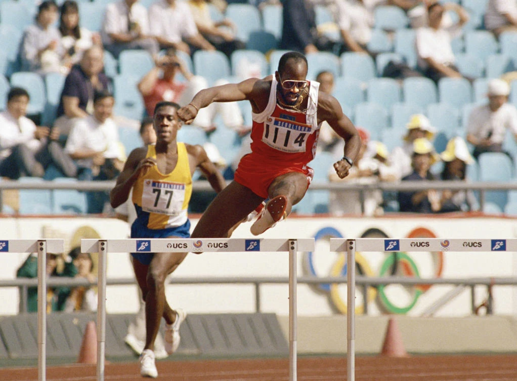 In this Sept. 23, 1988, file photo, Edwin Moses of the United States, right, pulls ahead of Allan Ince of Barbados during heat competition in the men’s 400 meter hurdles at the Olympics in Seoul, Korea. Three months after suffering the second of two traumatic head injuries in the span of six weeks, Edwin Moses is nearing 100 percent again. It’s been an amazing recovery for one of America’s best-known Olympic stars, and a man who is no stranger to making the impossible seem possible. (AP Photo/Lennox McLendon, File)
