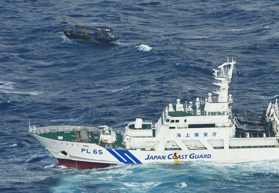 In this Nov. 29, 2017 photo, a wooden boat, top, is seen near a patrol ship of Japan Coast Guard. off Matsumae town, Hokkaido northern Japan. Japanese authorities are to inspect a decrepit boat carrying 10 men identifying as North Koreans drifting in rough seas off Japan’s northern island of Hokkaido, a latest in a wave of boats washing up on northern Japanese coasts. (Iori Sagisawa/Kyodo News via AP)