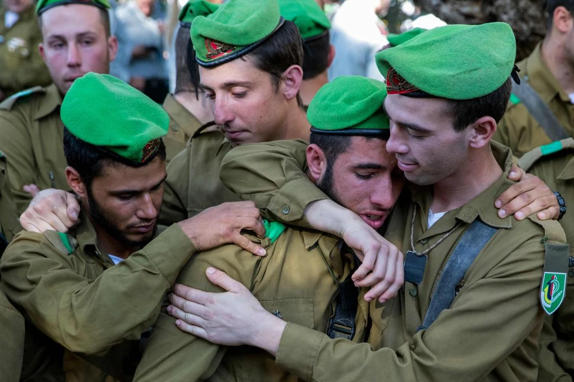 Comrades of Ron Yitzhak Kukia, a 19-year-old Israeli army sergeant who was murdered in the city of Arad last week, mourn during his funeral at the Kiryat Shaul military cemetery in Tel Aviv, on Dec. 3, 2017. Ron Kukia was found dying after being stabbed near a bus stop in Arad late on Nov. 30, his attackers had fled the scene. (AFP/Jack Guez)