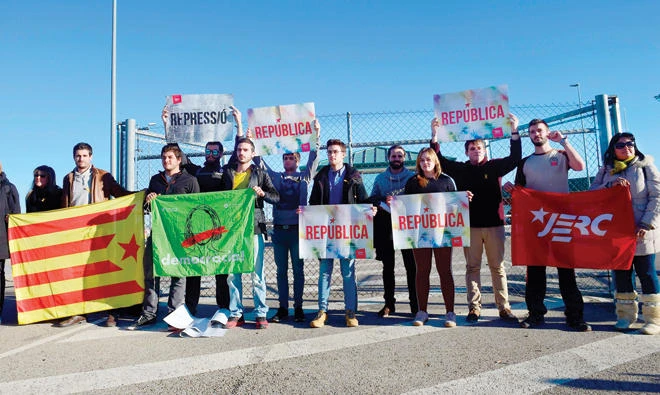 A group of people holds Catalan 'Estelada' flags and banners demanding a republic as they wait for the release of some Catalan former ministers outside the Estremera prison, some 80km east of Madrid, on Monday. (AFP)