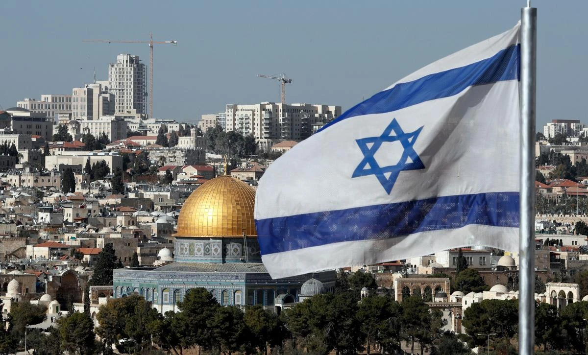 The Israeli flag flutters in front of the Dome of the Rock mosque and th city of Jerusalem, on Dec. 1, 2017. (AFP/Thomas Coex)