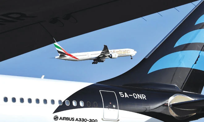 An Emirates Airline Boeing 777 aircraft is seen next to an Airbus A330-300 as it takes off from Abidjan. Global aviation body IATA expects Middle East carriers to boost profits in 2018 after a turbulent year which hit airline earnings across the region. (AFP)