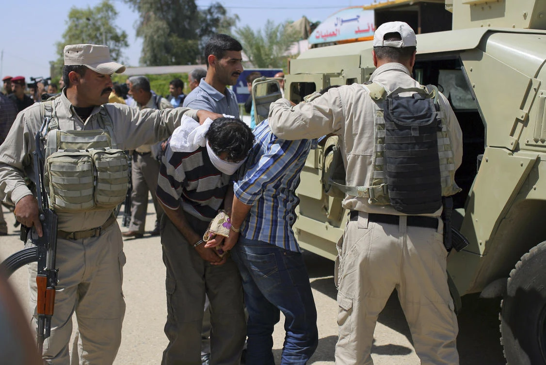 Blindfolded and handcuffed men are lead to custody after being arrested in Hillah, about 60 miles (95 kilometers) south of Baghdad, Iraq. The Iraqi security forces arrested three men during a recent security operation in the city who they suspected of members of Daesh. Human Rights Watch said in a report released on Tuesday, Dec. 5, 2017, that thousands of people suspected of having ties to Daesh face widespread rights violations in Iraqi custody. (AP Photo, File)