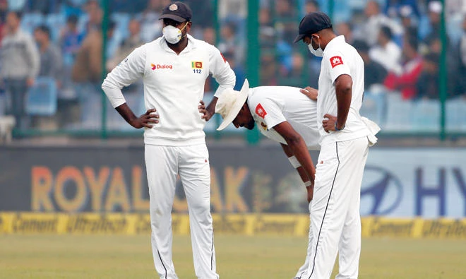 Sri Lanka’s Suranga Lakmal, centre, vomits during the fourth day’s play. (AP)