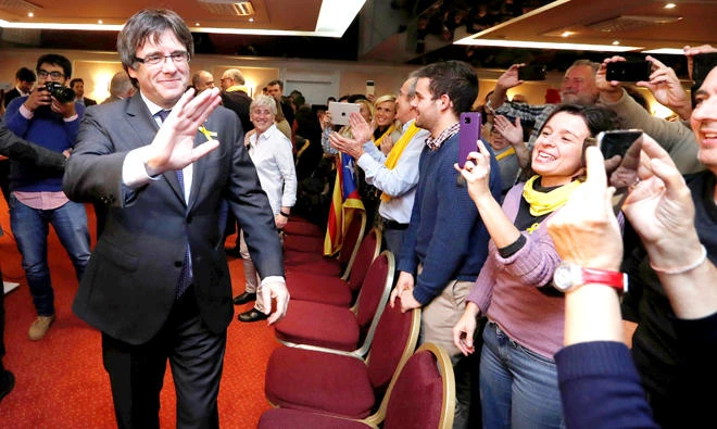 Ousted Catalan leader Carles Puigdemont is welcomed by supporters gathering on the eve of a Catalan pro-independence giant protest in Brussels Wednesday. (Reuters)