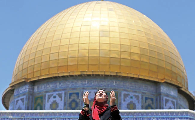 A Palestinian woman prays at Al-Aqsa compound. (Reuters)