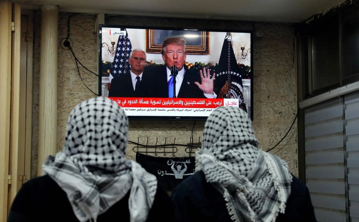 Palestinian men watching an address given by US President Donald Trump at a cafe in Jerusalem. US President Donald Trump recognized the disputed city of Jerusalem as Israel's capital on December 6, 2017, a historic decision that overturns decades of US policy and risks triggering a fresh spasm of violence in the Middle East. (AFP)