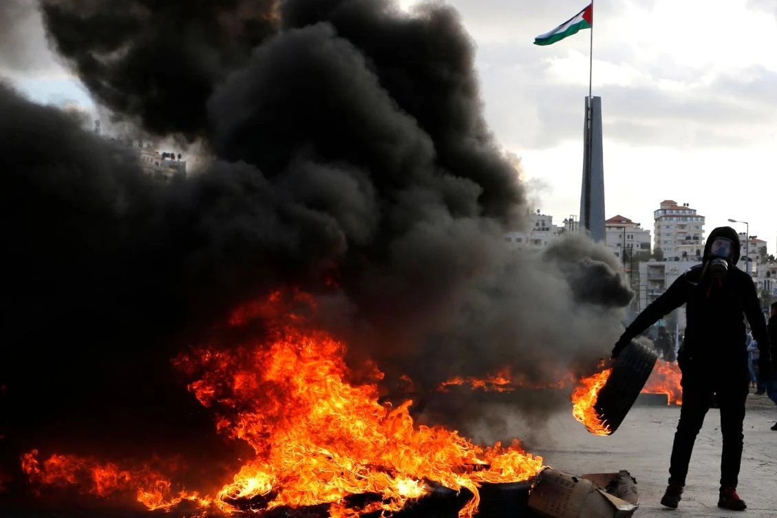 A Palestinian protester burns tires during clashes with Israeli troops following a protest against US President Donald Trump's decision to recognize Jerusalem as the capital of Israel. (AFP)