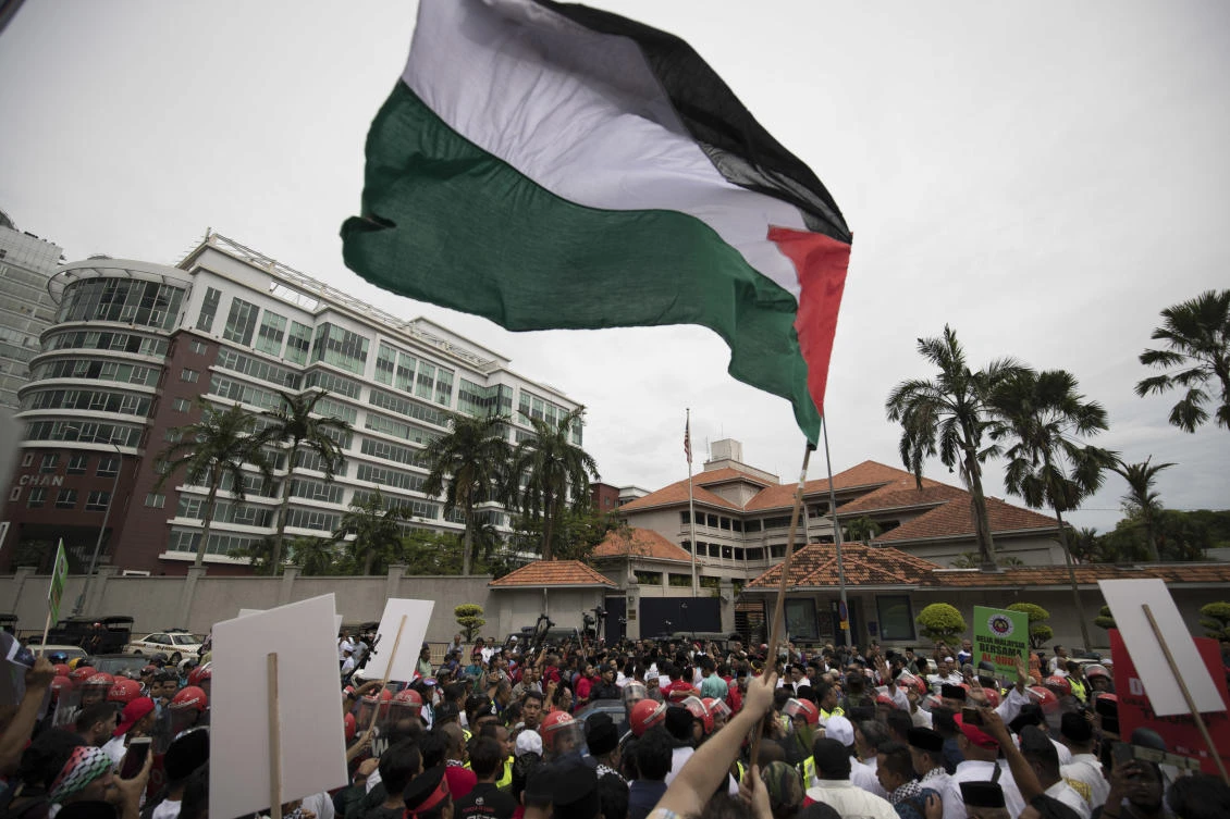 Protesters waves Palestine flags during a protest outside the US Embassy in Kuala Lumpur, Malaysia, Friday, Dec. 8, 2017. Malaysian Muslims, including members of the ruling party, were protesting outside the US Embassy over Washington’s controversial move to recognize Jerusalem as Israel’s capital. (AP Photo/Vincent Thian)