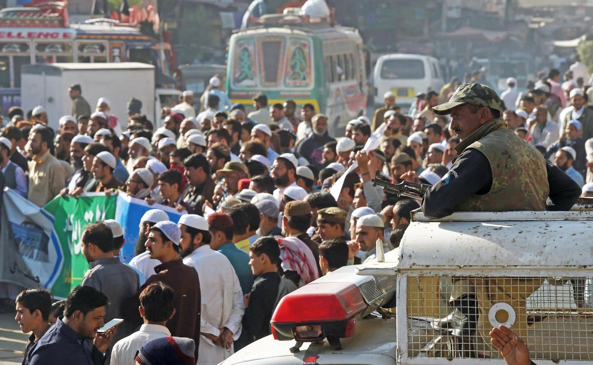 A Pakistani police commander watches protesters shout anti-US and anti-Israeli slogans during a protest in Karachi on Friday. (AFP)