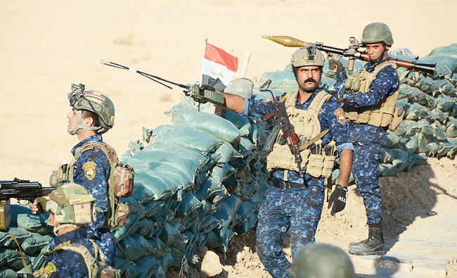 Iraqi security forces members hold a position as they advance toward the Salaheddine province in the western desert bordering Syria, in this November 26, 2017 photo, in a bid to flush out remaining Daesh group fighters in the Al-Jazeera region. (AFP)
