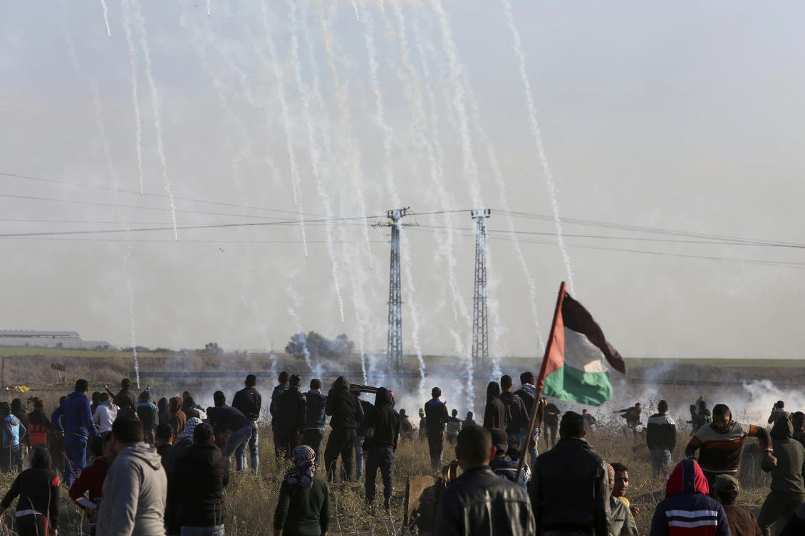 Palestinian protesters look at teargas fired by Israeli soldiers during clashes on the Israeli border following a protest against US President Donald Trump’s decision to recognize Jerusalem as the capital of Israel. (AP)