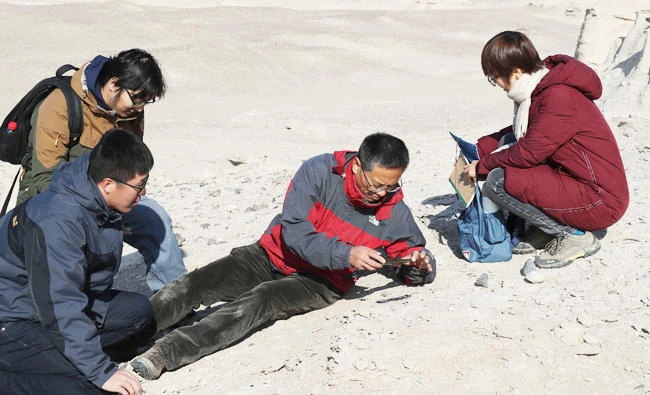 This photo taken on November 30, 2017 shows Chinese scientist Wang Xiaolin (C) taking a photo as he inspects the terrain in Hami, in northwestern China's Xinjiang Region. (AFP)