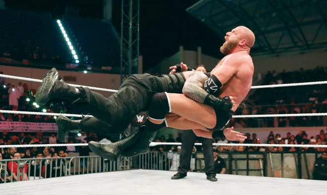 Triple H feels the full force of a Roman Reigns hard-hitting smash in Abu Dhabi. (WWE)