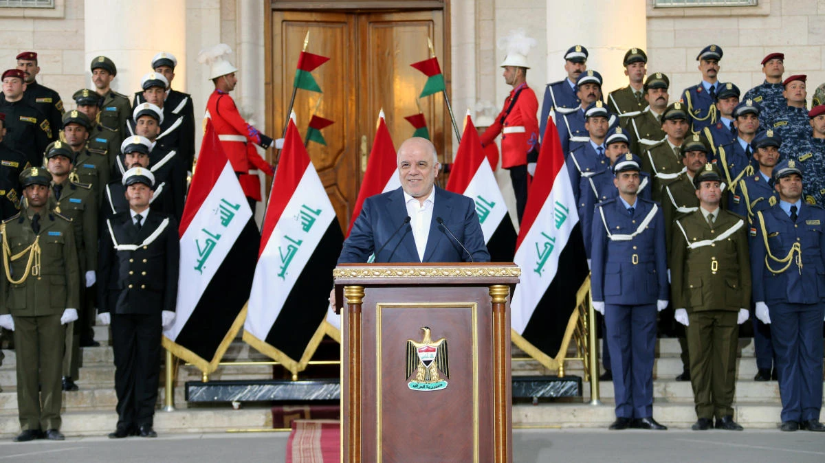 Iraqi Prime Minister Haider Al-Abadi has declared December 10 an annual national holiday. Above, Abadi speaks before security forces after declaring final victory over Daesh on Saturday. (Handout via Reuters)
