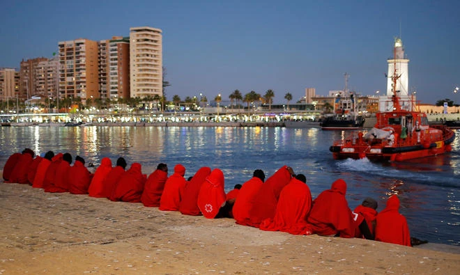 Migrants, part of a group intercepted aboard a dinghy off the coast in the Mediterranean Sea, rest after arriving on a rescue boat at the Port of Malaga, Spain on December 7, 2017. (Reuters)