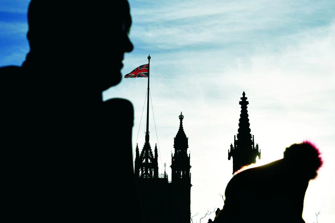 People pass a Union flag flying on the Houses of Parliament in London. Britain and the EU have reached a historic deal on Brexit divorce terms, but Brussels swiftly warned that even harder talks lie ahead on a future relationship after the split. (AFP)