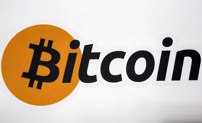 FILE PHOTO: A Bitcoin logo is displayed at the Bitcoin Center New York City in New York's financial district in NY, U.S. on July 28, 2015. REUTERS/Brendan McDermid/File Photo