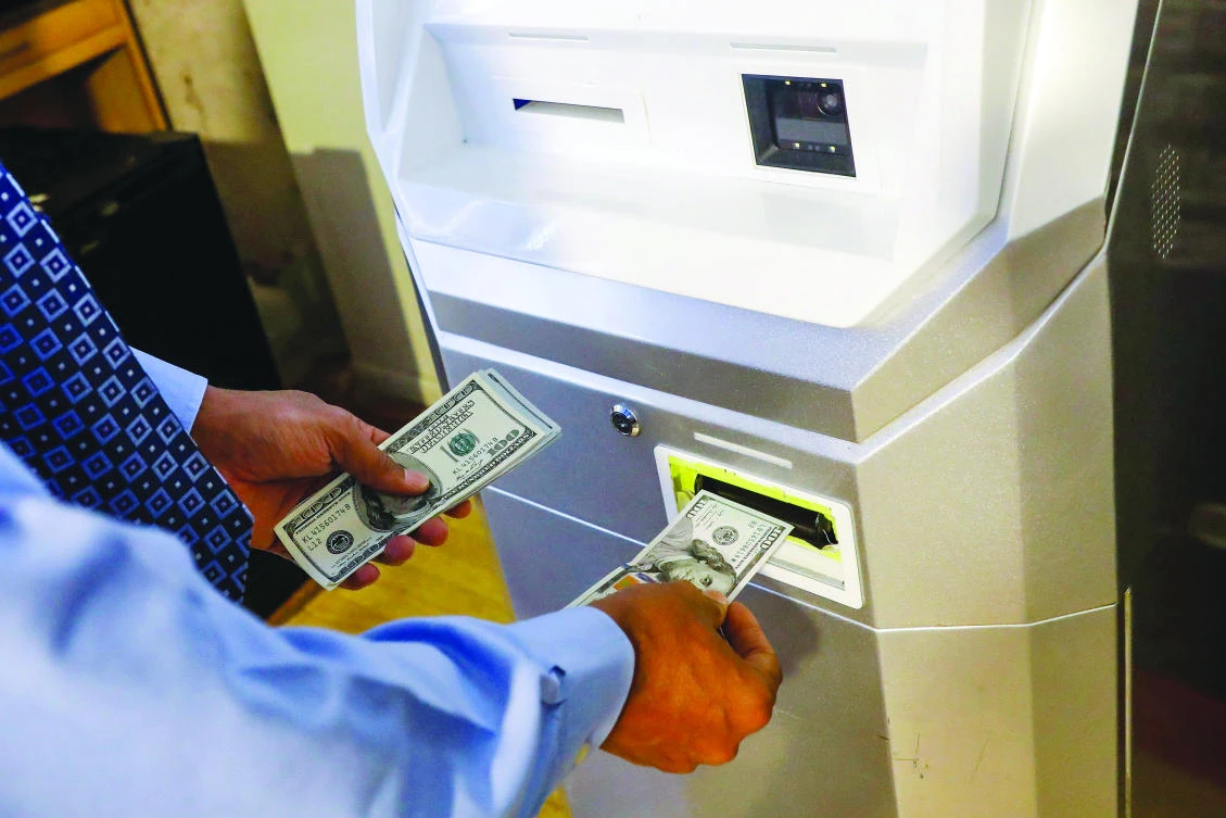 A man feeds money into a bitcoin ATM in New York. The digital currency has surged in recent weeks, prompting fears of a bubble in the making, but that has not deterred a number of Dubai-based entrepreneurs investing in the digital currency. (Reuters)