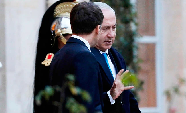 French President Emmanuel Macron (L) speaks with Israeli Prime Minister Benjamin Netanyahu as he leaves the Elysee Palace on Sunday in Paris. (AFP)