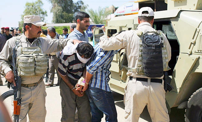 In this April 5, 2015, file photo, blindfolded and handcuffed men are lead to custody after being arrested in Hillah, about 60 miles south of Baghdad, Iraq. (AP)