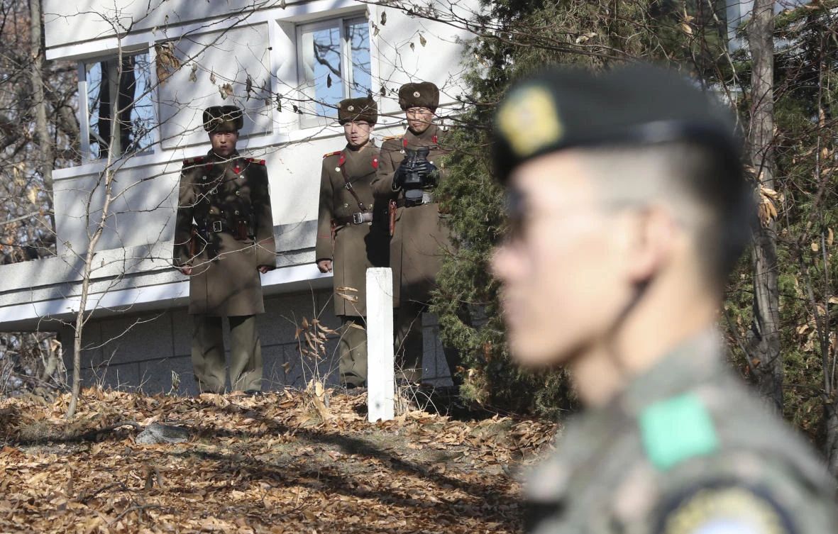 North Korean soldiers look at the South side as a South Korean stands guard near the spot where a North Korean soldier crossed the border on Nov. 13 at the Panmunjom, in the Demilitarized Zone, South Korea, Monday, Nov. 27, 2017. (AP)