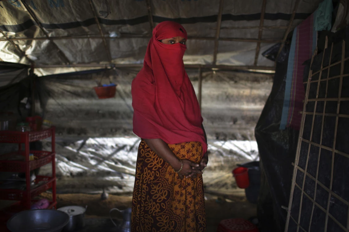 In this Monday, Nov. 20, 2017, photo, F, 22, who says she was raped by members of Myanmar’s armed forces in June and again in September, clutches her hands around her pregnant belly as she is photographed in her tent in Kutupalong refugee camp in Bangladesh. (AP)