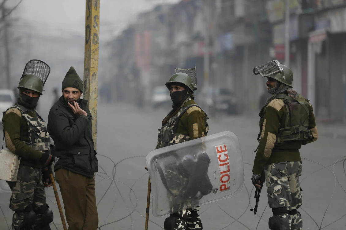 Indian paramilitary soldiers and a policeman, second from left, guard a checkpoint during a strike to mark International Human Rights Day in Srinagar, India, Sunday, Dec. 10, 2017. (AP Photo/Mukhtar Khan)