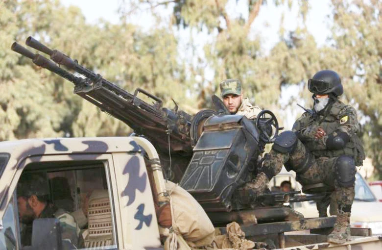 Members of Libyan pro-government forces ride an army vehicle in Benghazi. (File photo/Reuters)