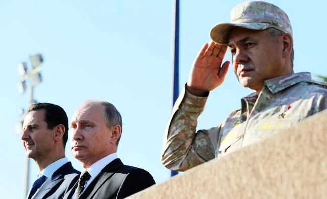 Russian President Vladimir Putin (C), Defence Minister Sergei Shoigu (R) and Syrian President Bashar al-Assad visit the Hmeymim air base in Latakia Province, Syria on Monday. (REUTERS)